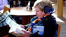 Schiffsheck Sonnenaufgangskaffee: eine Frau informiert sich bei strahlender Sonne ber Fahrroute und die Antarktis ...